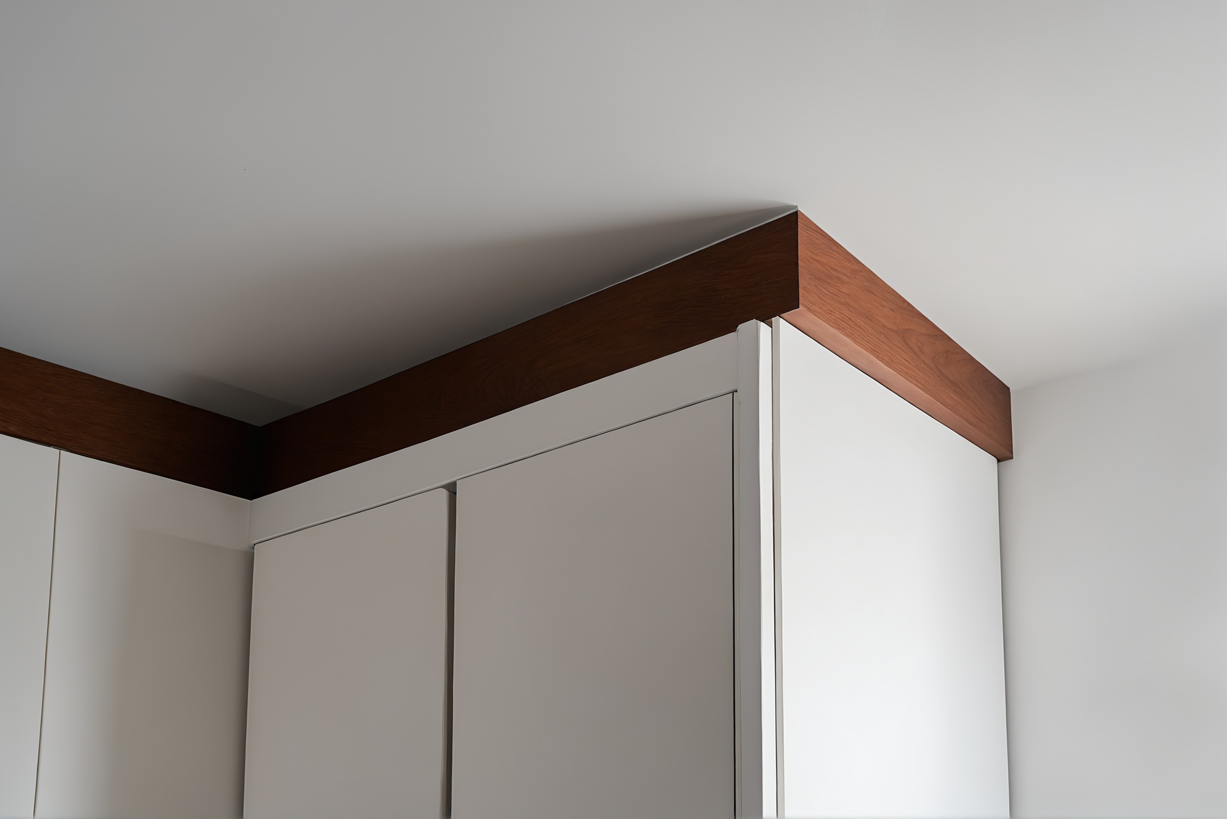 Close-up of a crisp shadow gap where built-in joinery meets the ceiling